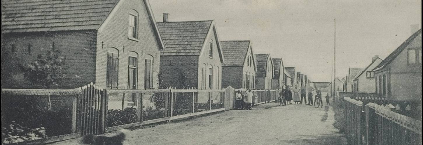 zwart wit prentbriefkaart met een rij huizen en poserende mensen in Haaften. uitgever P.A. van Rijswijk.