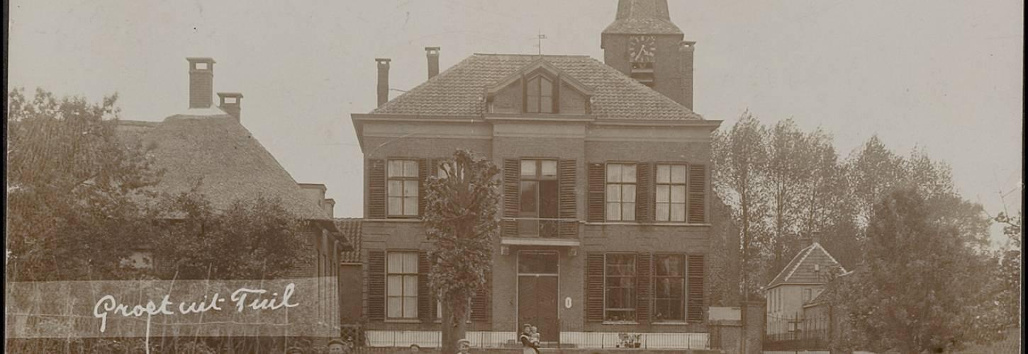 Prentbriefkaart met kinderen die poseren voor de pastorie in Tuil  met tekst Groet uit Tuil