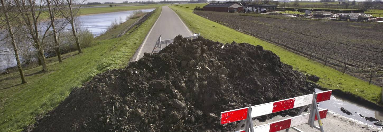 dijk die is afgesloten met een bord en een berg aarde